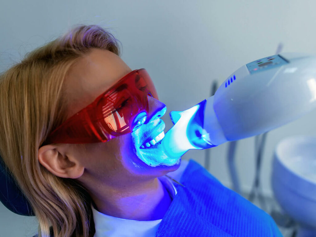 patient wearing protective sun glasses receiving teeth whitening